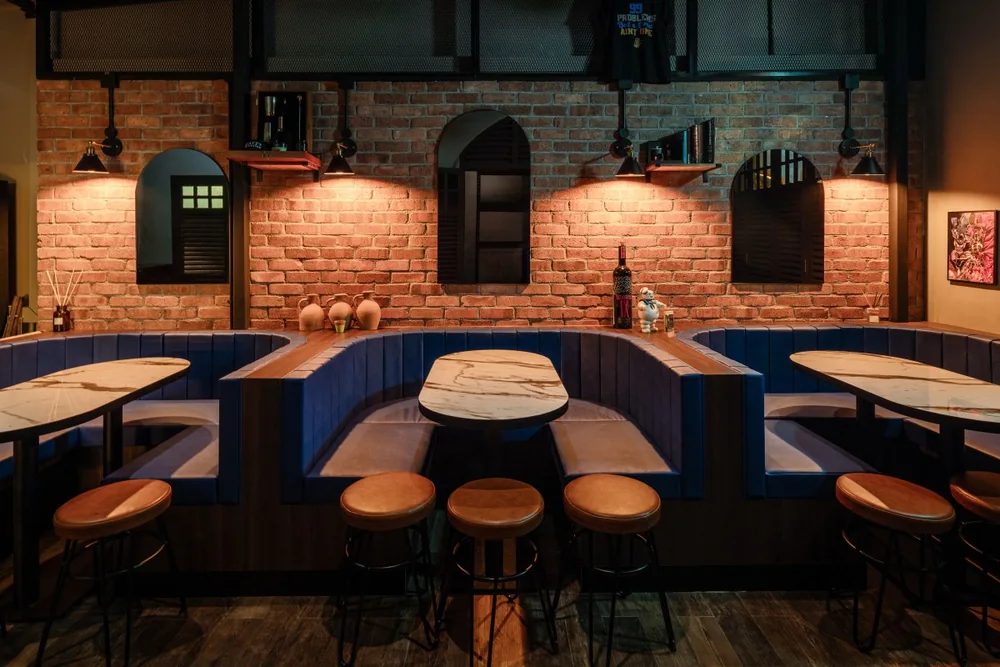 Blue booths and long tables in the lounge at Brooklyn Bar