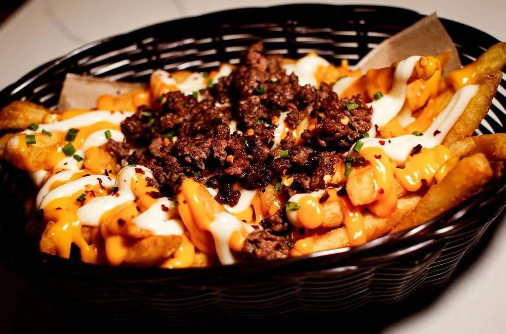 Fully loaded fries with seasoned beef, cheese sauce and mayo in a basket