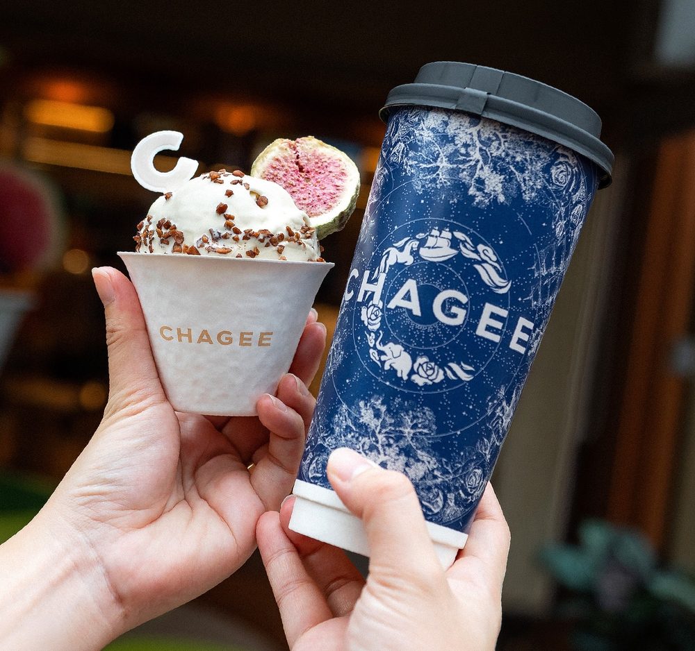 A cup of CHAGEE Geelato held up next to a CHAGEE milk tea cup