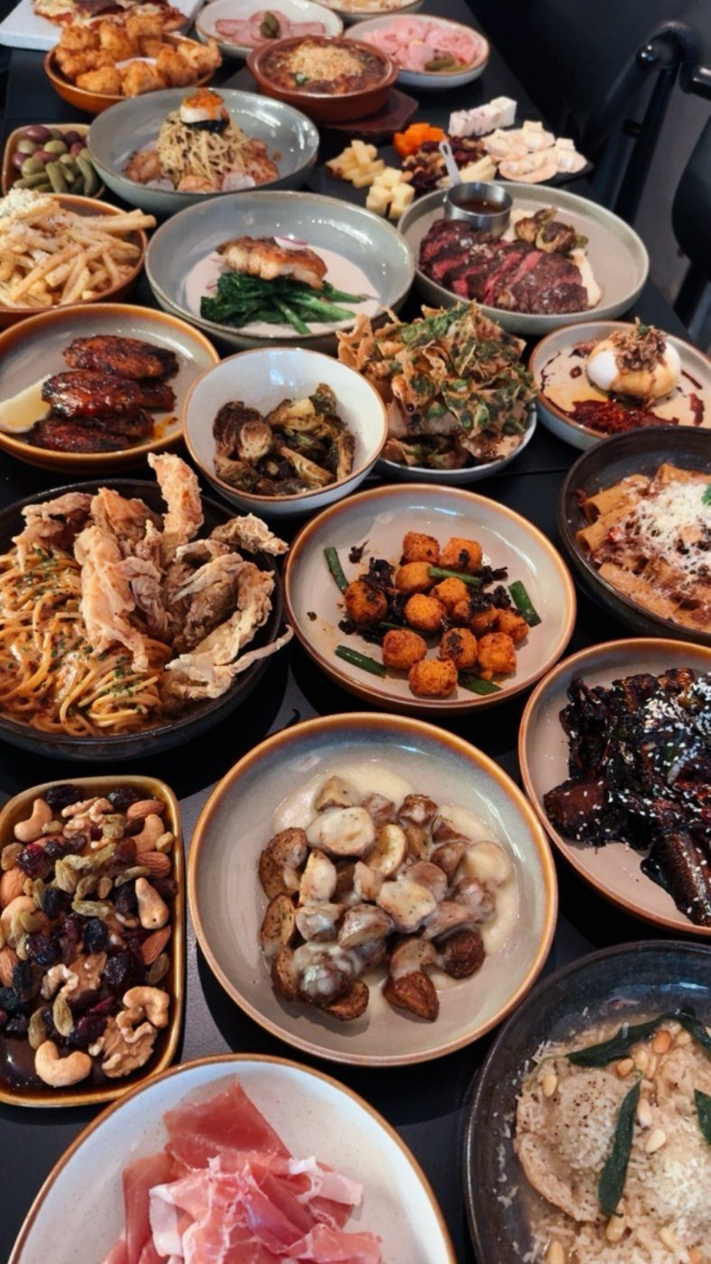 A full table of small plates, cheeses and cured meats at Cheeselads