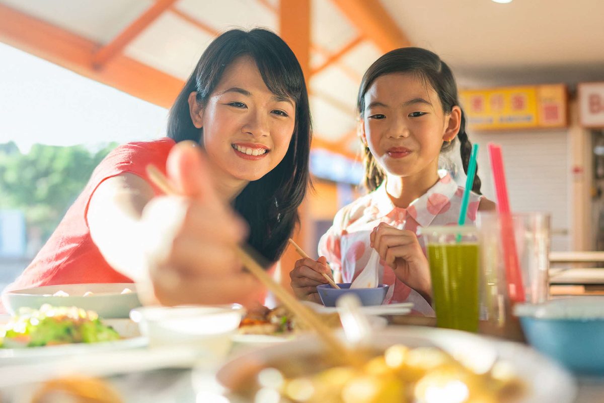 Mother and daughter eating at a hawker centre table