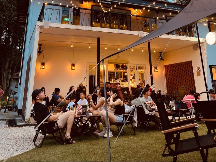 Outdoor lawn seating with camping chairs at NOMADS Seletar