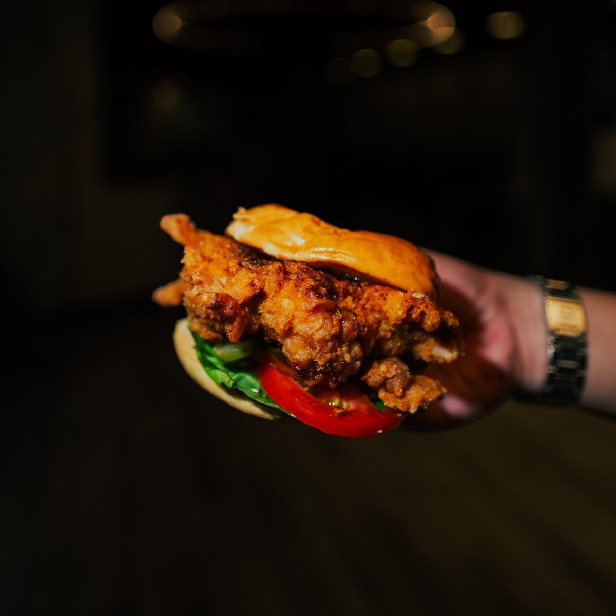 A crispy fried chicken burger held up at Sonic Bistro
