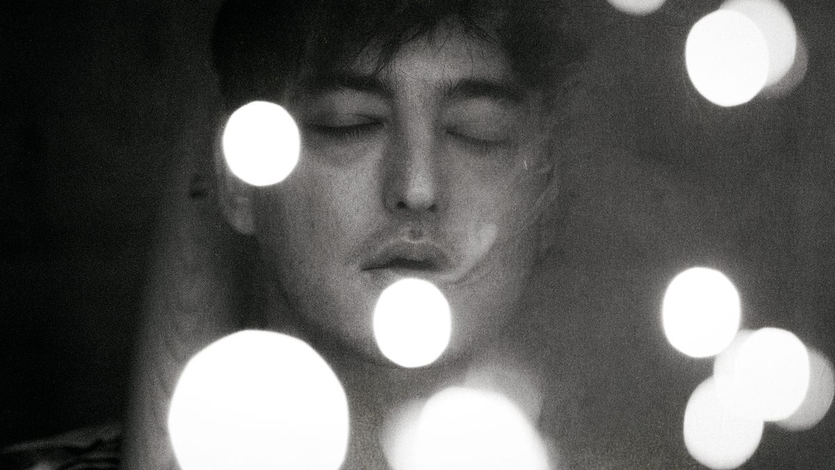 Black and white portrait of Joji with soft bokeh lights, SOLARIS tour photo