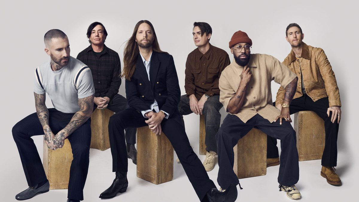 Maroon 5 band members seated on wooden blocks, press photo