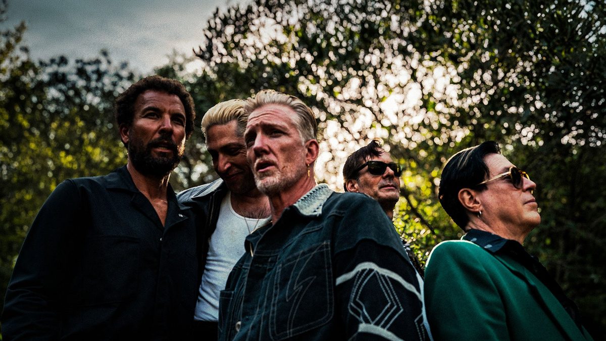 Queens of the Stone Age band members outdoors under trees, press photo