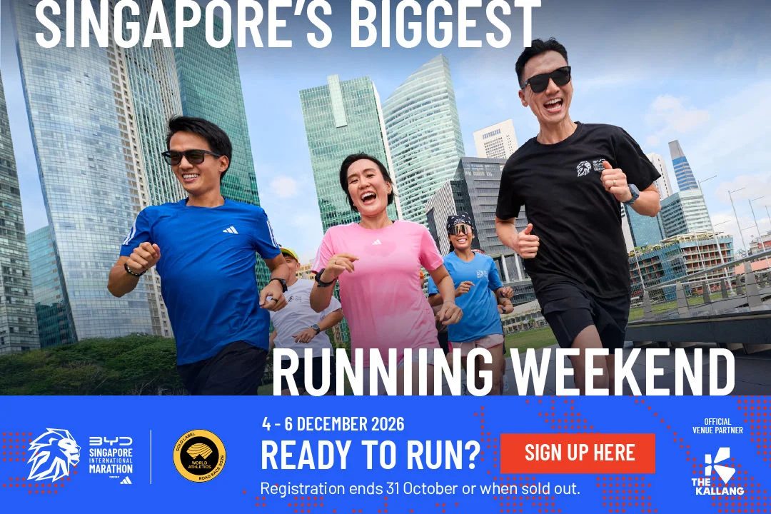 Runners in Singapore International Marathon 2026 shirts jogging past the city skyline