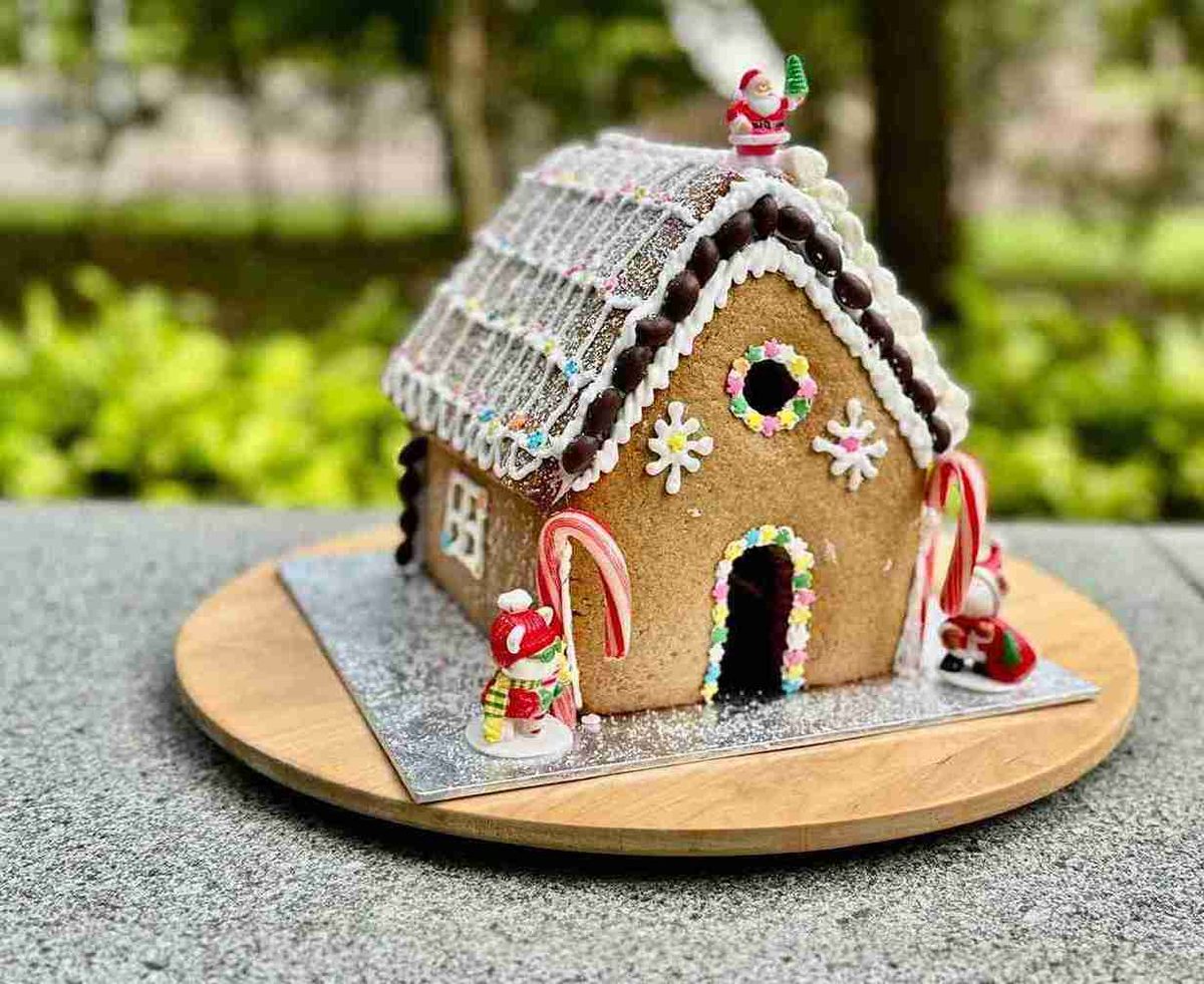 A finished gingerbread house with candy canes and white icing