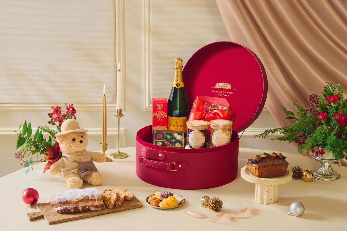 The Fullerton Yuletide Elegance hamper in a red hatbox with champagne, bear and stollen