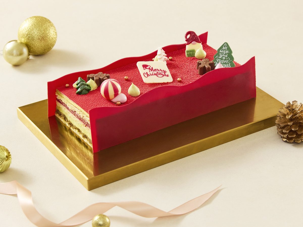 The Fullerton Pistachio and Raspberry Yule Log with red glaze on a gold board