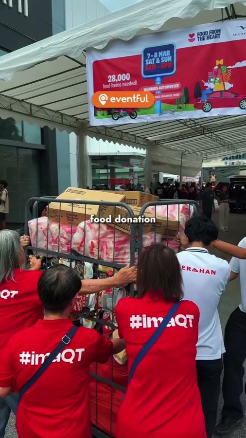 Volunteers push a cage of donated rice and biscuits under the Heart on Wheels banner at Wearnes, Leng Kee Road