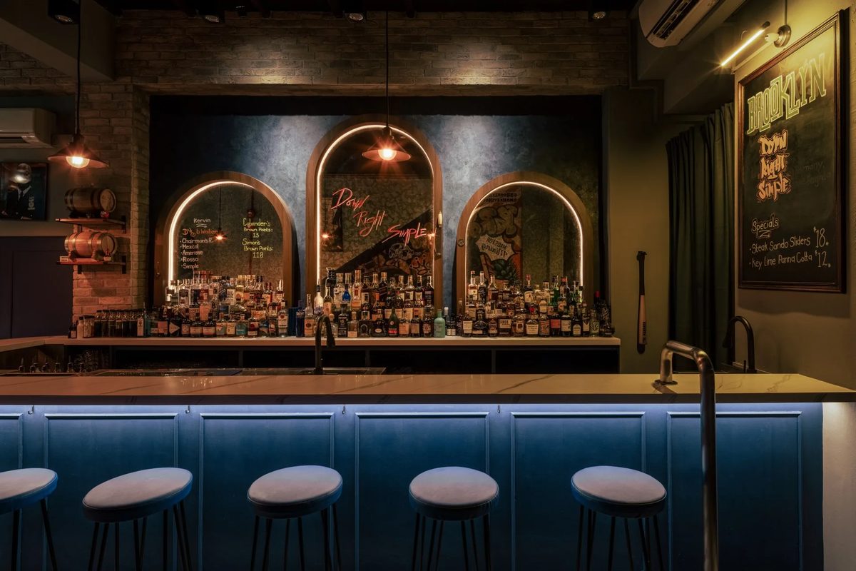 The bar counter at Brooklyn Bar with lit arches and bottles behind it