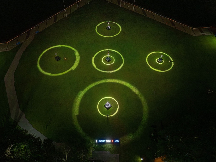 Aerial view of the WAVE light installation rings glowing on the lawn at i Light Singapore