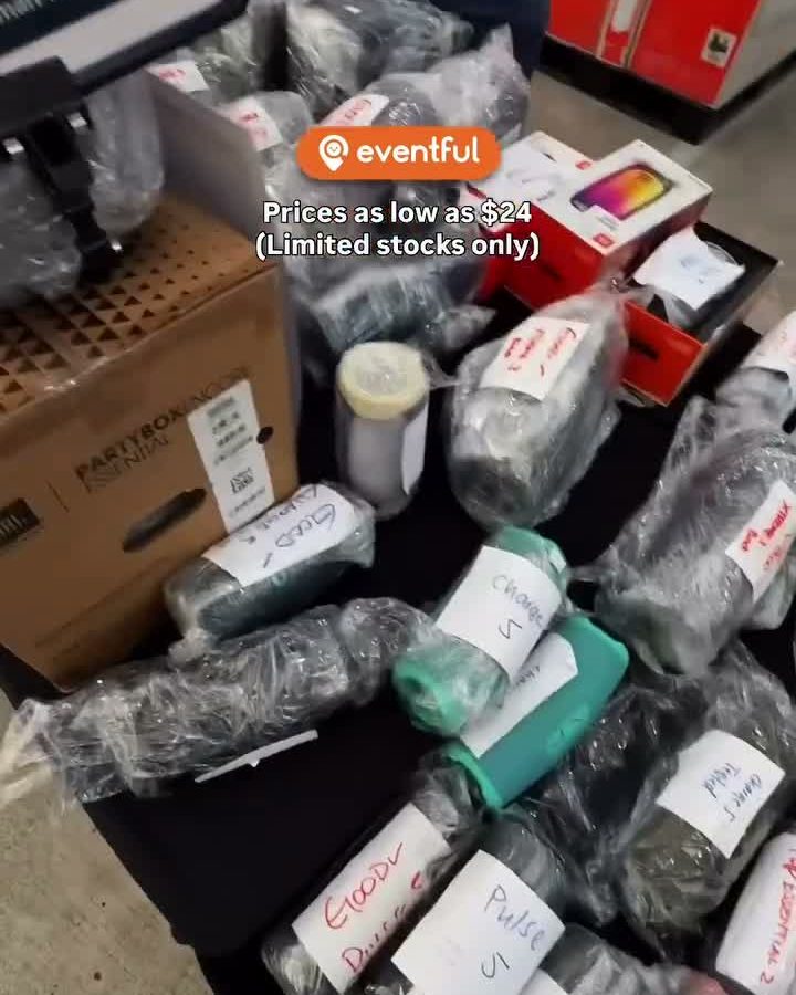 Bagged JBL speakers with handwritten condition labels on a table at the Marsiling audio warehouse sale