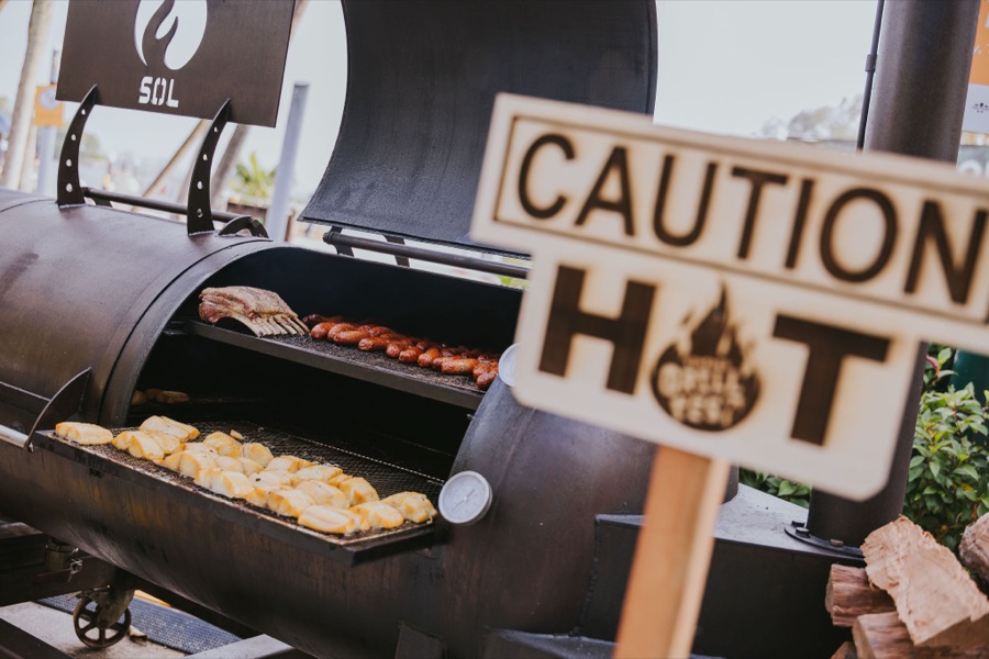 A giant offset smoker loaded with ribs, sausages and corn at Sentosa GrillFest