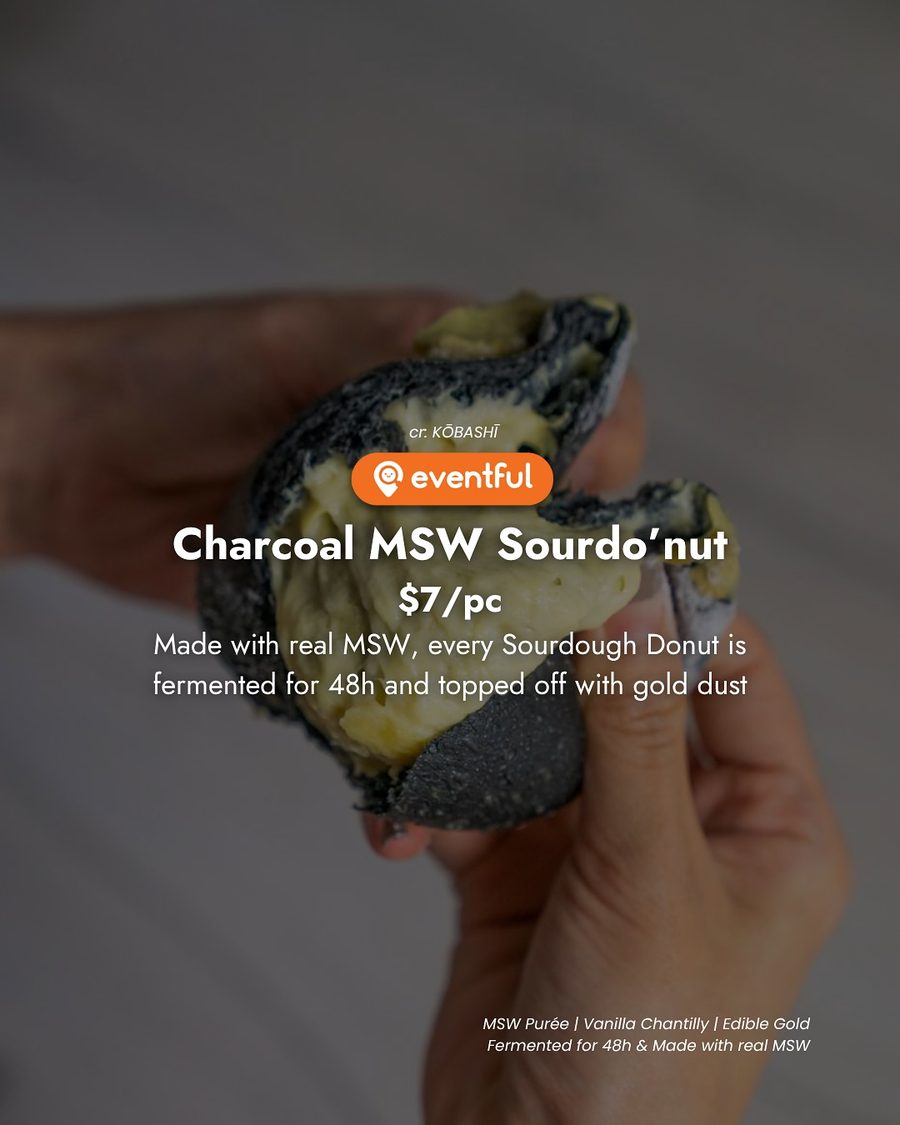 A torn charcoal MSW durian sourdo'nut from KOBASHI showing the yellow durian filling