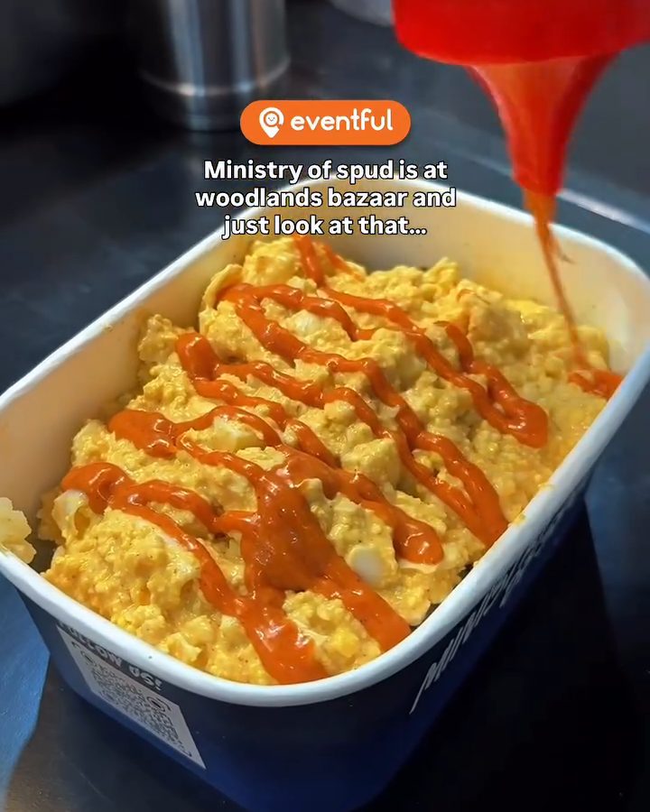 Bang bang sauce being squeezed over an egg mayo baked potato at the Ministry of Spud Woodlands stall