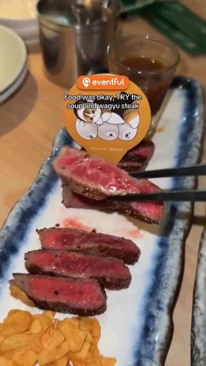 Sliced Tochigi wagyu steak on a blue plate with a mofusand pick at Sushi Tei
