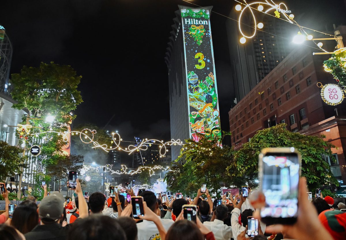 Crowd filming the Christmas projection show on Hilton Singapore Orchard at night