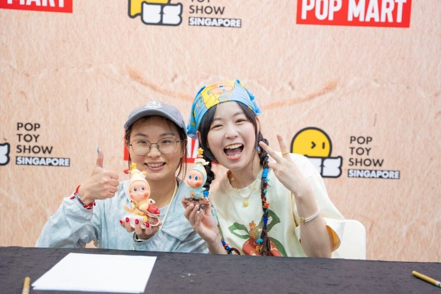 Artists signing collectible figures at POP TOY SHOW Singapore