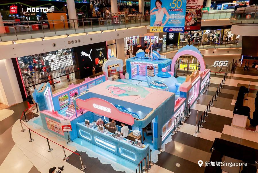 The MINISO x MOETCH Sanrio pop-up booth in the Bugis+ Level 2 Atrium, pastel blue and pink with a giant teapot and a cashier counter
