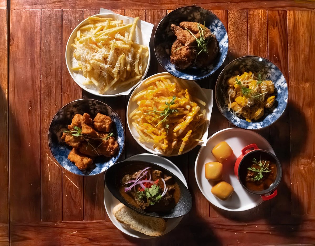 A table spread of fries, chicken wings and mains at Sonic Bistro