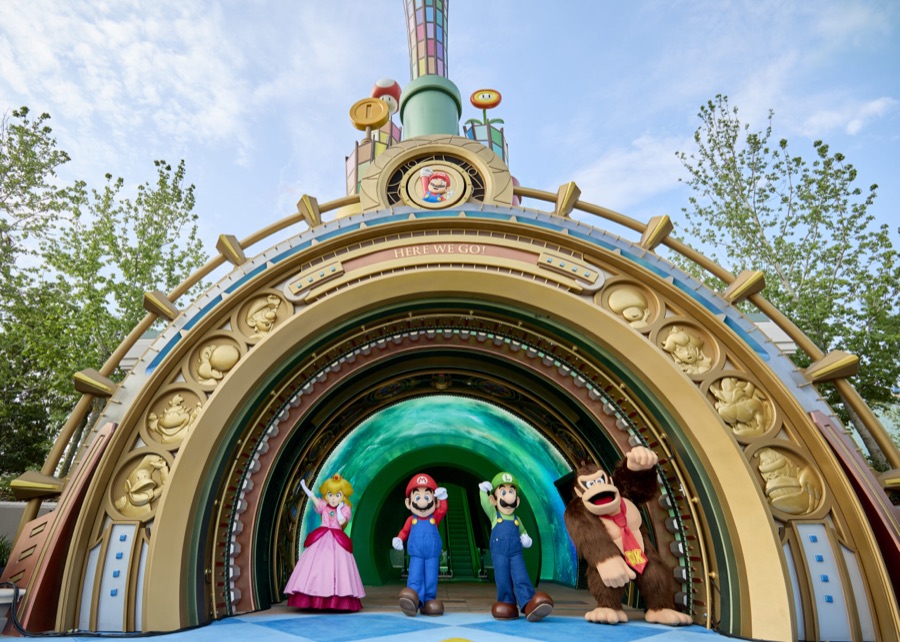Princess Peach, Mario, Luigi and Donkey Kong at the warp-pipe style entrance of Super Nintendo World at Epic Universe
