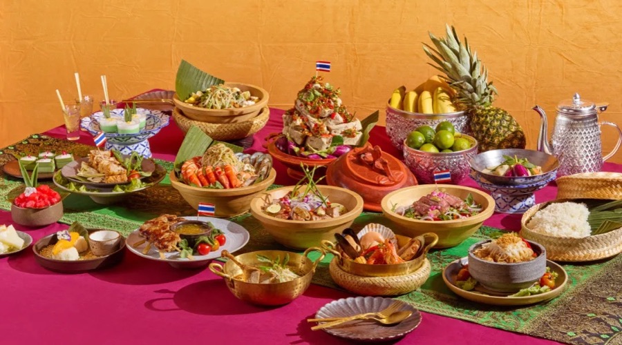 The Thailand Flavourscape spread at Food Capital: Thai dishes with flags, sticky rice, tom yum and tropical fruit on a magenta table