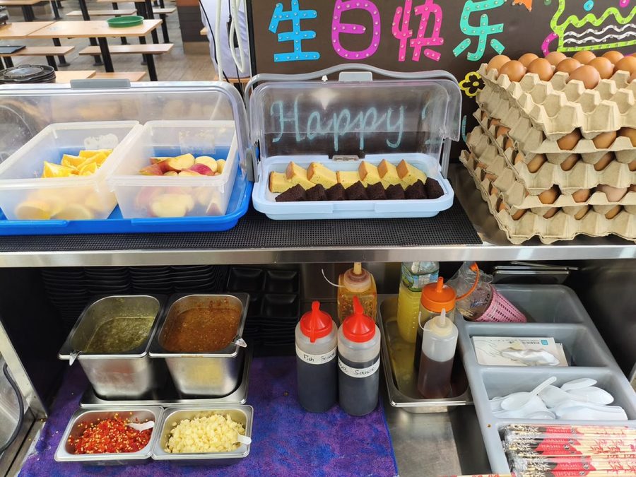 The sauce and condiment station at Family Mookata with chilli sauces and minced garlic