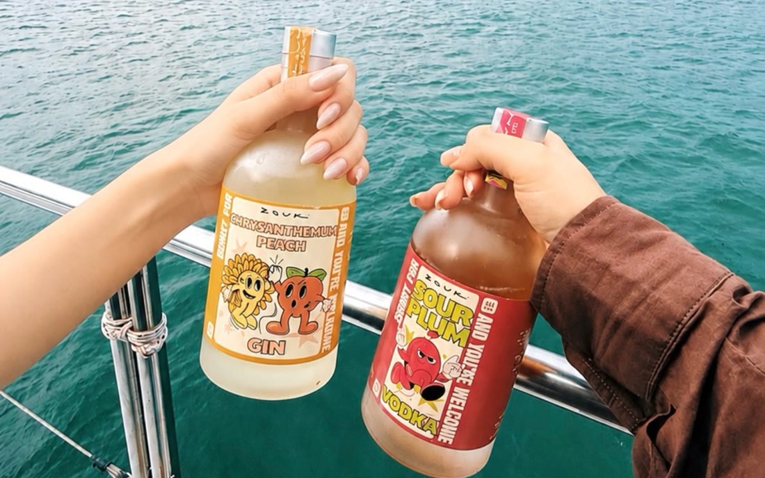 Two friends clinking Sorry For: bottles over the sea off a yacht